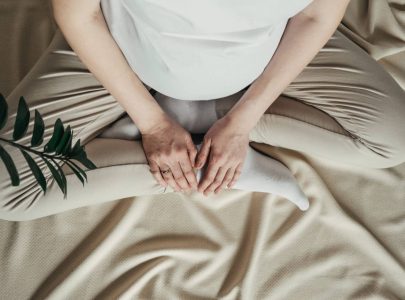 Pregnant woman holds green sprout plant near her belly. Concept pregnancy, maternity, eco sustainable lifestyle, gynecology. Symbol of new life, wellbeing, fertility, unborn baby health.