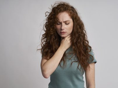 Young woman with serious sore throat