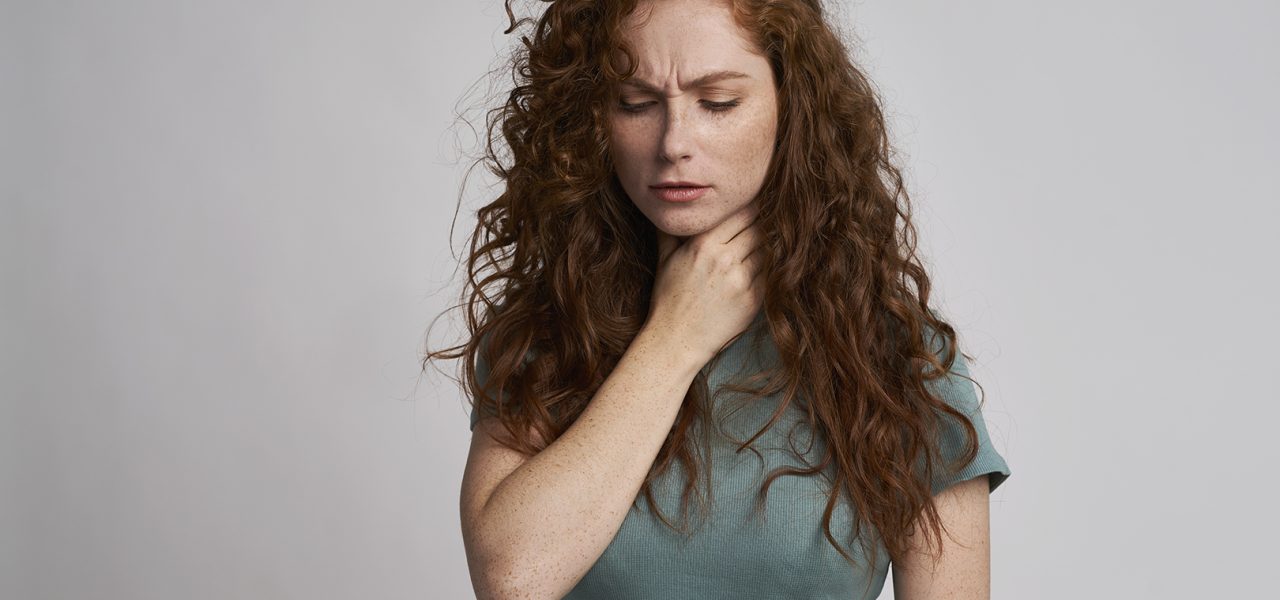 Young woman with serious sore throat